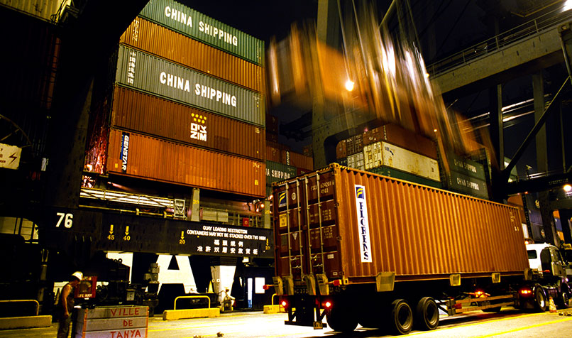 Containers are loaded off a ship and onto trucks at a container terminal in Hong Kong.