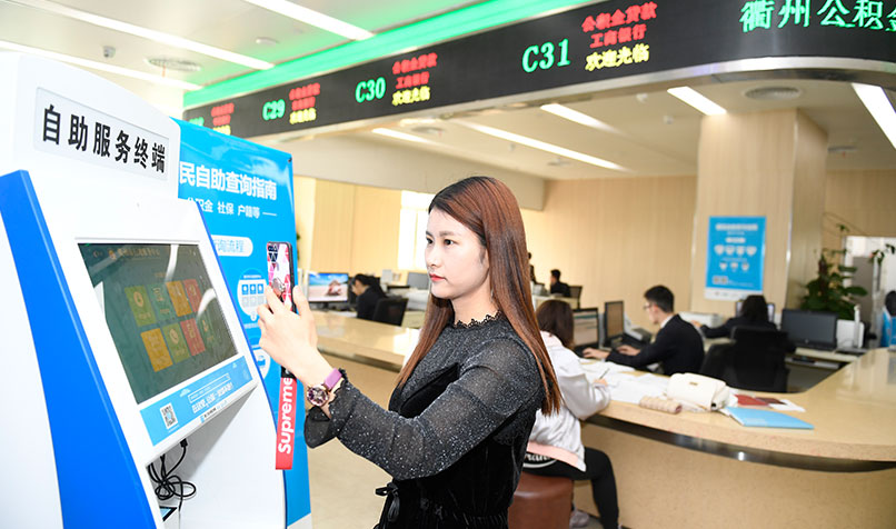 A banking customer verifies her identity to check her social security fund balance using an electronic ID card, part of mobile payment app Alipay, in Hangzhou, China.