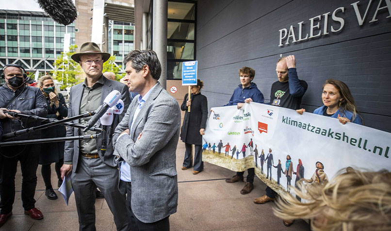 Lawyer Roger Cox (R) and Donald Pols, director of Milieudefensie (Dutch for “environmental defence”) speak to the media after the court decision against Royal Dutch Shell in the Netherlands in May 2021.